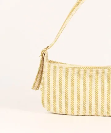Product Description: GAIA – Organic Textured Jute Baguette Made out of artisanal handicraft jute fabric, this baguette is sturdy, simple yet has an earthy finish to it. Cotton lining inside, with adjustable straps by 3 knots. Color: Cream and Beige Stripes Length: 5.5 inches Width: 10 inches Height: 4 inches Price: ₹900/-