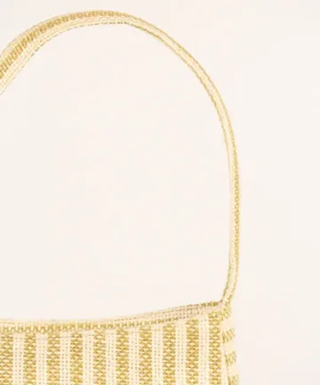 Product Description: GAIA – Organic Textured Jute Baguette Made out of artisanal handicraft jute fabric, this baguette is sturdy, simple yet has an earthy finish to it. Cotton lining inside, with adjustable straps by 3 knots. Color: Cream and Beige Stripes Length: 5.5 inches Width: 10 inches Height: 4 inches Price: ₹900/-