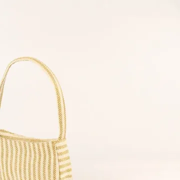 Product Description: GAIA – Organic Textured Jute Baguette Made out of artisanal handicraft jute fabric, this baguette is sturdy, simple yet has an earthy finish to it. Cotton lining inside, with adjustable straps by 3 knots. Color: Cream and Beige Stripes Length: 5.5 inches Width: 10 inches Height: 4 inches Price: ₹900/-