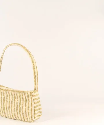 Product Description: GAIA – Organic Textured Jute Baguette Made out of artisanal handicraft jute fabric, this baguette is sturdy, simple yet has an earthy finish to it. Cotton lining inside, with adjustable straps by 3 knots. Color: Cream and Beige Stripes Length: 5.5 inches Width: 10 inches Height: 4 inches Price: ₹900/-